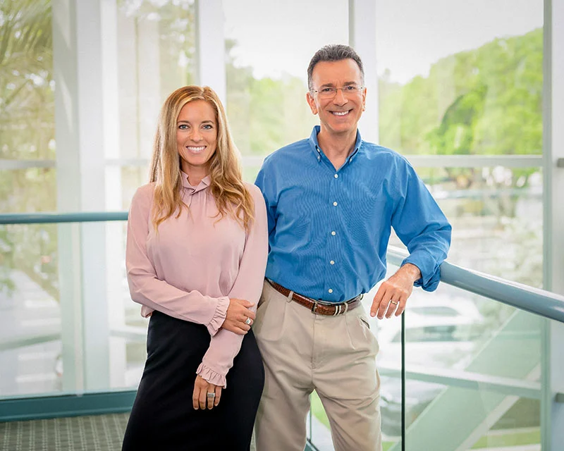 Brittany Johnston, FNP-C and Dr. David Rosenberg standing together in the practice, in bright natural light.